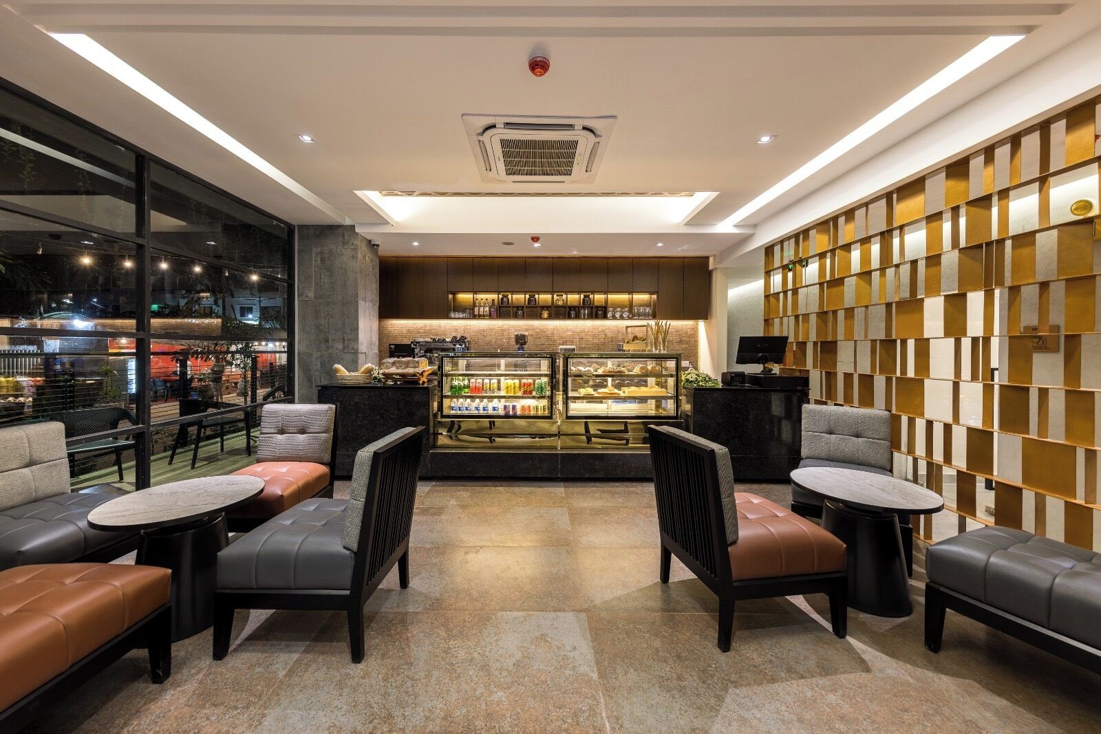 Ein modernes Interieur mit Sitzbereichen, einer Bar und Blick ins Freie.