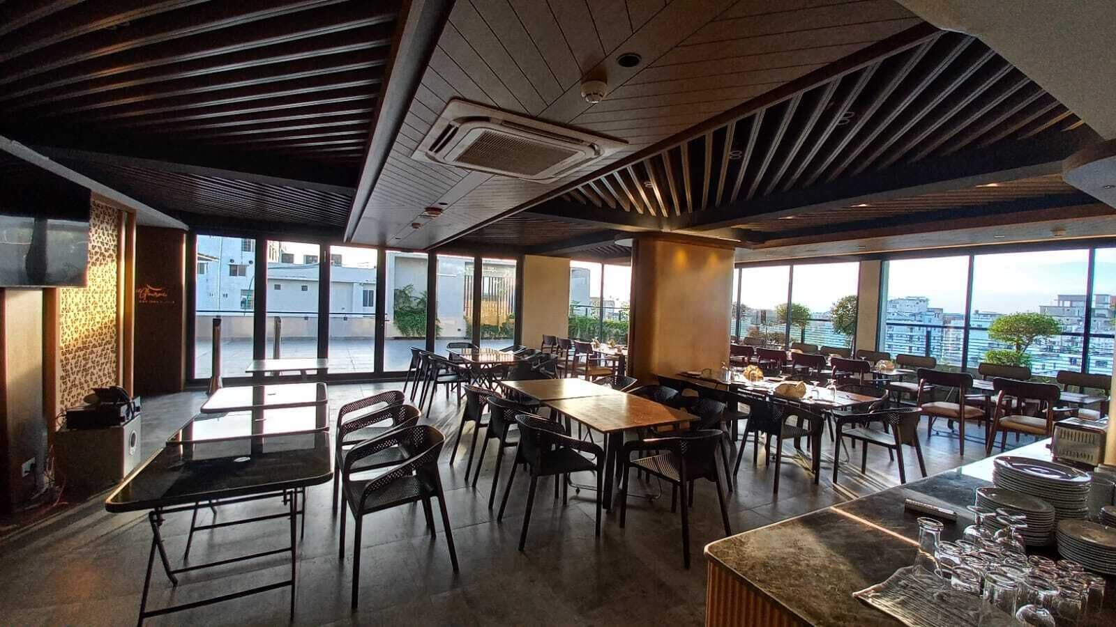 A spacious dining area with high ceilings, large windows, and a view of the cityscape.