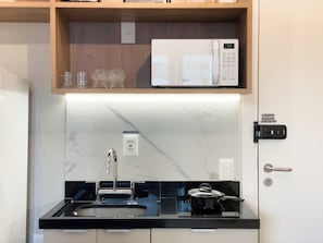 A modern kitchen with a built-in microwave, a sink, and a stove.