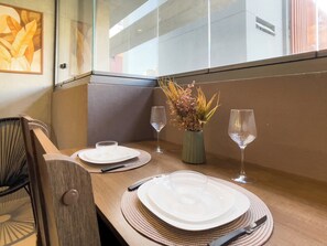A dining table set with plates, cutlery, and a vase with flowers. - Botaní (São Paulo)