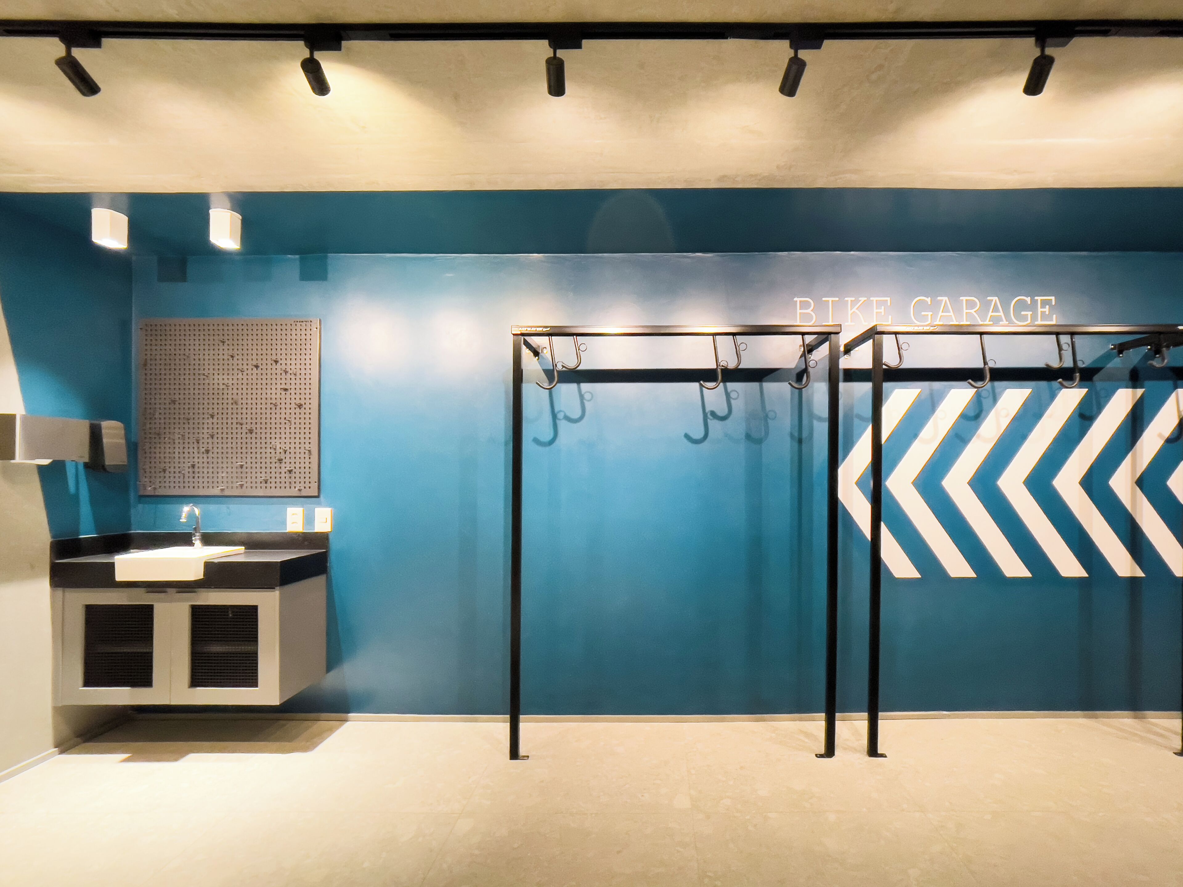 Une salle de bain équipée d’un lavabo, d’un miroir, d’un porte-serviettes et d’un distributeur de serviettes fixé au mur.