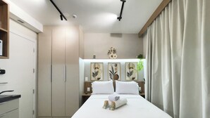 A hotel room with a bed, a wardrobe, a desk, and a nightstand. - Botaní (São Paulo)