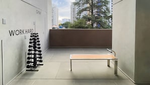 A gym with a wall-mounted dumbbell rack and a bench. - Botaní (São Paulo)
