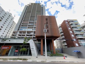 Um edifício moderno com fachada singular, janelas amplas e número do endereço visível.