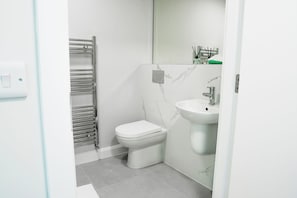 Deluxe kamer, balkon | Badkamer | Een douche, een haardroger, handdoeken, zeep