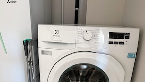 Una lavadora de carga frontal con panel de control, un código QR y una etiqueta que indica que es el modelo 600 SENSICARE de 10kg.