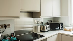 Una cocina moderna con electrodomésticos de acero inoxidable, microondas y tostadora.