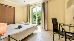 Ein Hotelzimmer mit Bett, Schreibtisch, Stuhl und einem Vorhangfenster.