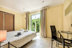 Ein Hotelzimmer mit Bett, Schreibtisch, Stuhl und einem Vorhangfenster.