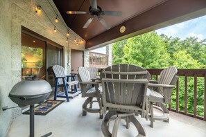 Een overdekt terras met stoelen en een barbecue.