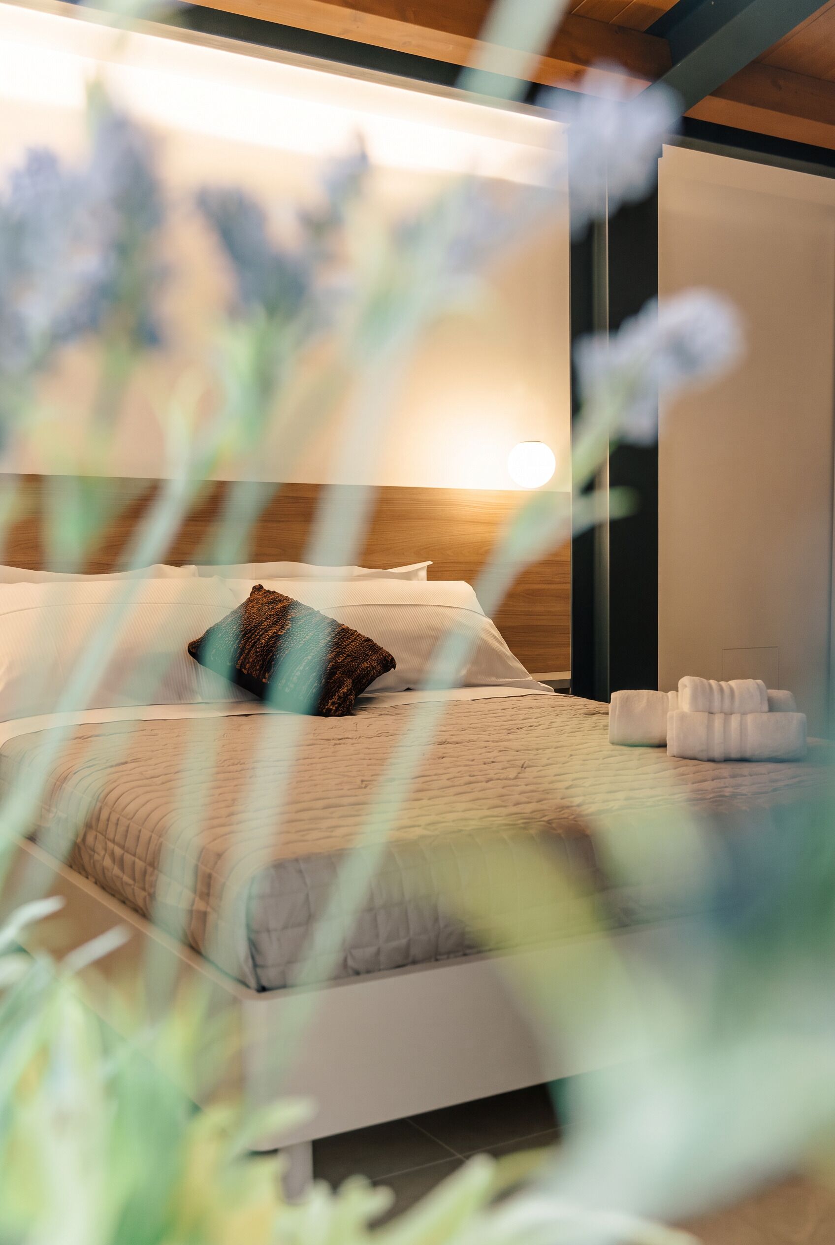 Un dormitorio moderno con una cama, almohadas y una mesita de noche.