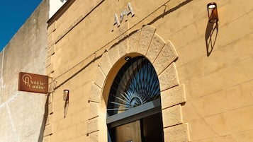 La façade d’un immeuble, ornée d’une enseigne indiquant « Antiche Cantine Bed & Breakfast », et dotée d’une grande entrée en arc de cercle.