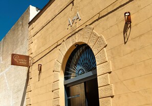 Fachada de edificio con un letrero que dice 'Antiche Cantine Bed & Breakfast' y una gran entrada en arco.
