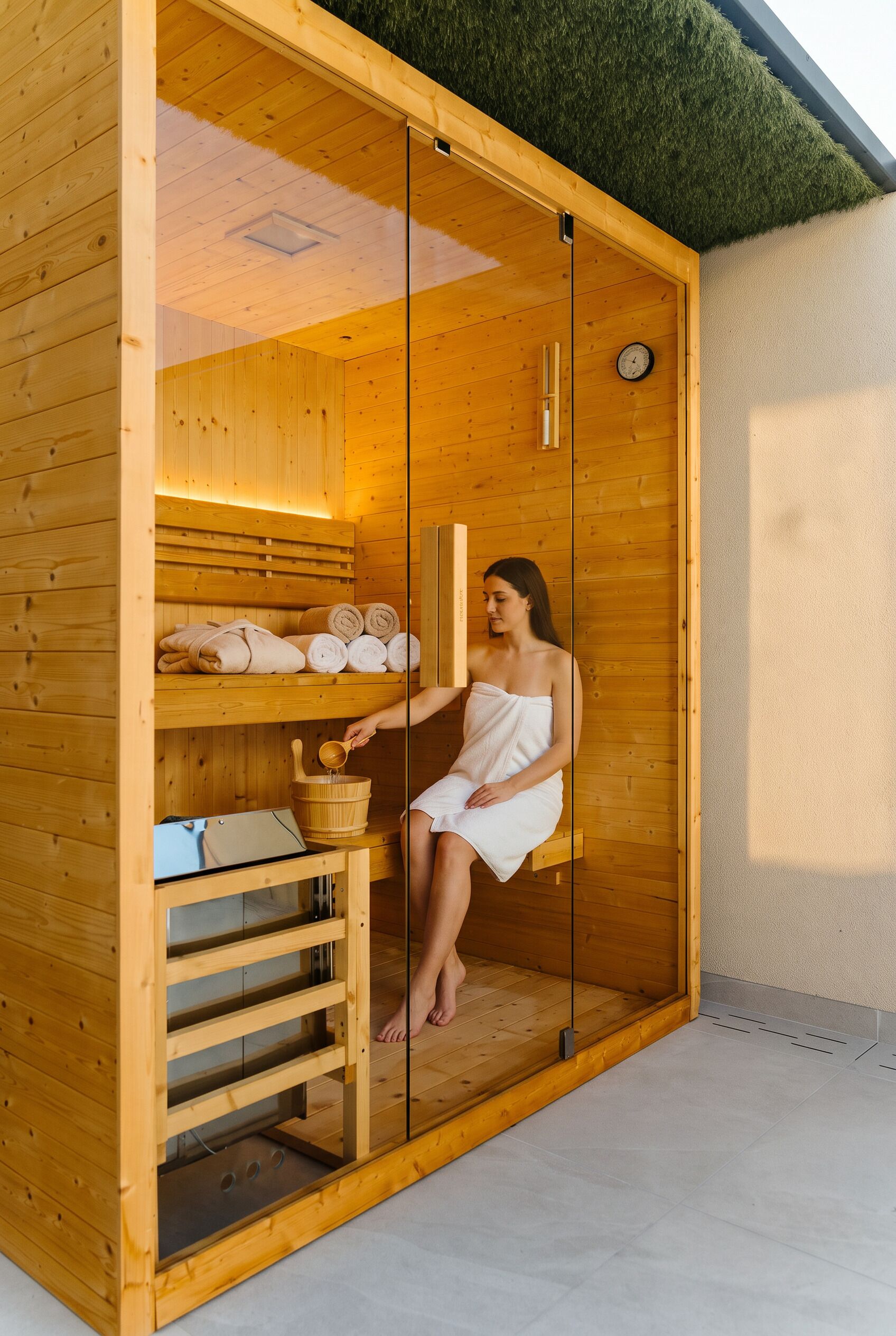 Uma sauna com paredes de madeira, um banco e toalhas.