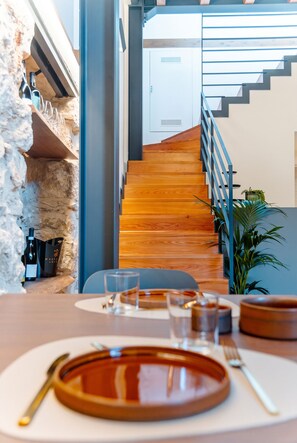 A dining area with a wooden staircase leading to a white room. - Antiche Cantine Bed & Breakfast (Alcamo)