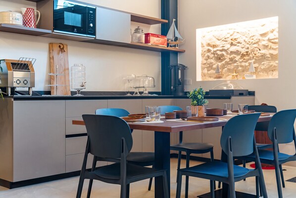 A modern kitchen with a built-in microwave, a coffee machine, and a water dispenser.