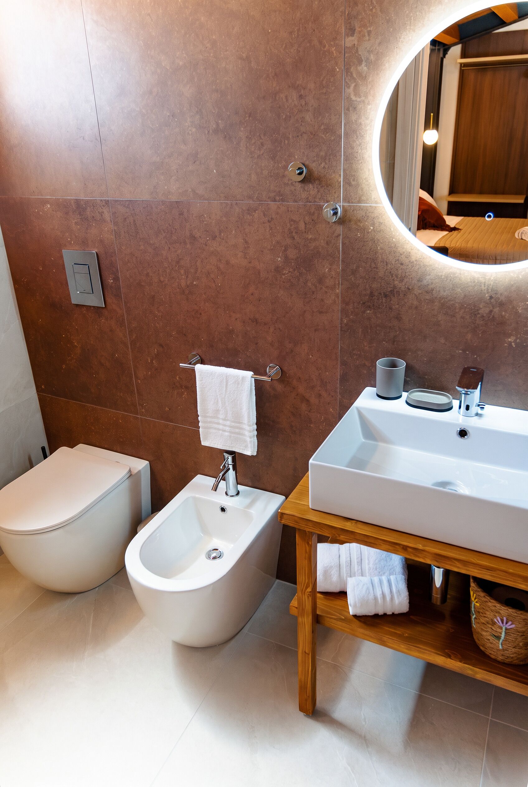 Une salle de bain moderne équipée d’un bidet, d’un lavabo et d’un miroir.