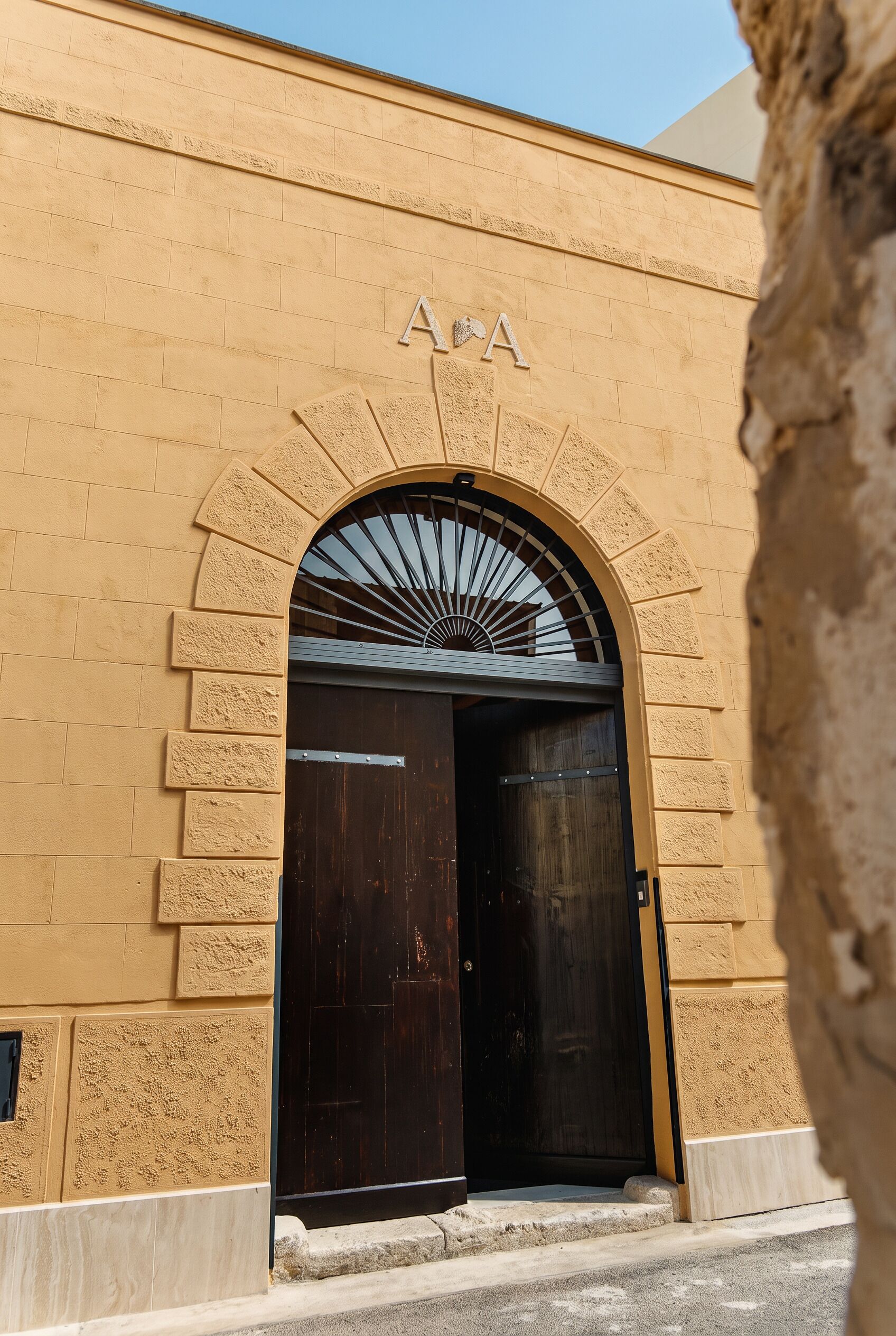 Una entrada de edificio con un arco grande y un letrero encima.