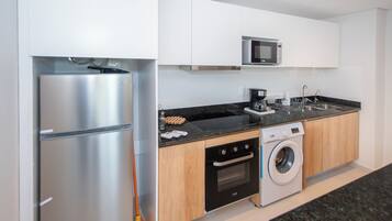 A modern kitchen with stainless steel appliances, a microwave, and a built-in washing machine.