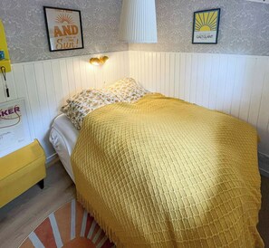Ein Schlafzimmer mit Bett, Nachttisch, Lampe und Wanddekorationen.