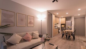 A modern living room with a sofa, coffee table, and artwork on the wall. - Pedro Valdivia Apartments by Andes STR (Providencia)