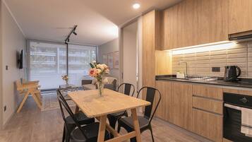 A modern kitchen with wooden cabinets, a black countertop, and a built-in oven.
