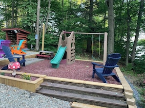 A playground with a slide, swings, and Adirondack chairs. - Peaceful Lakefront Retreat,  Fish, Kayak, Unplug 18 Min from Middlebury (Leicester)