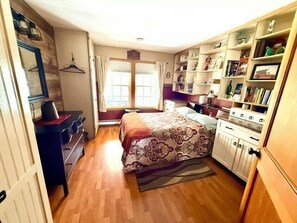 Un dormitorio con cama, cómoda y estantería.