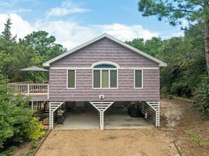 Ein zweistöckiges Haus mit überdachter Veranda und Garage.