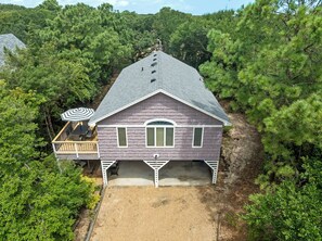 Ein zweistöckiges Haus mit überdachter Terrasse und Garage.