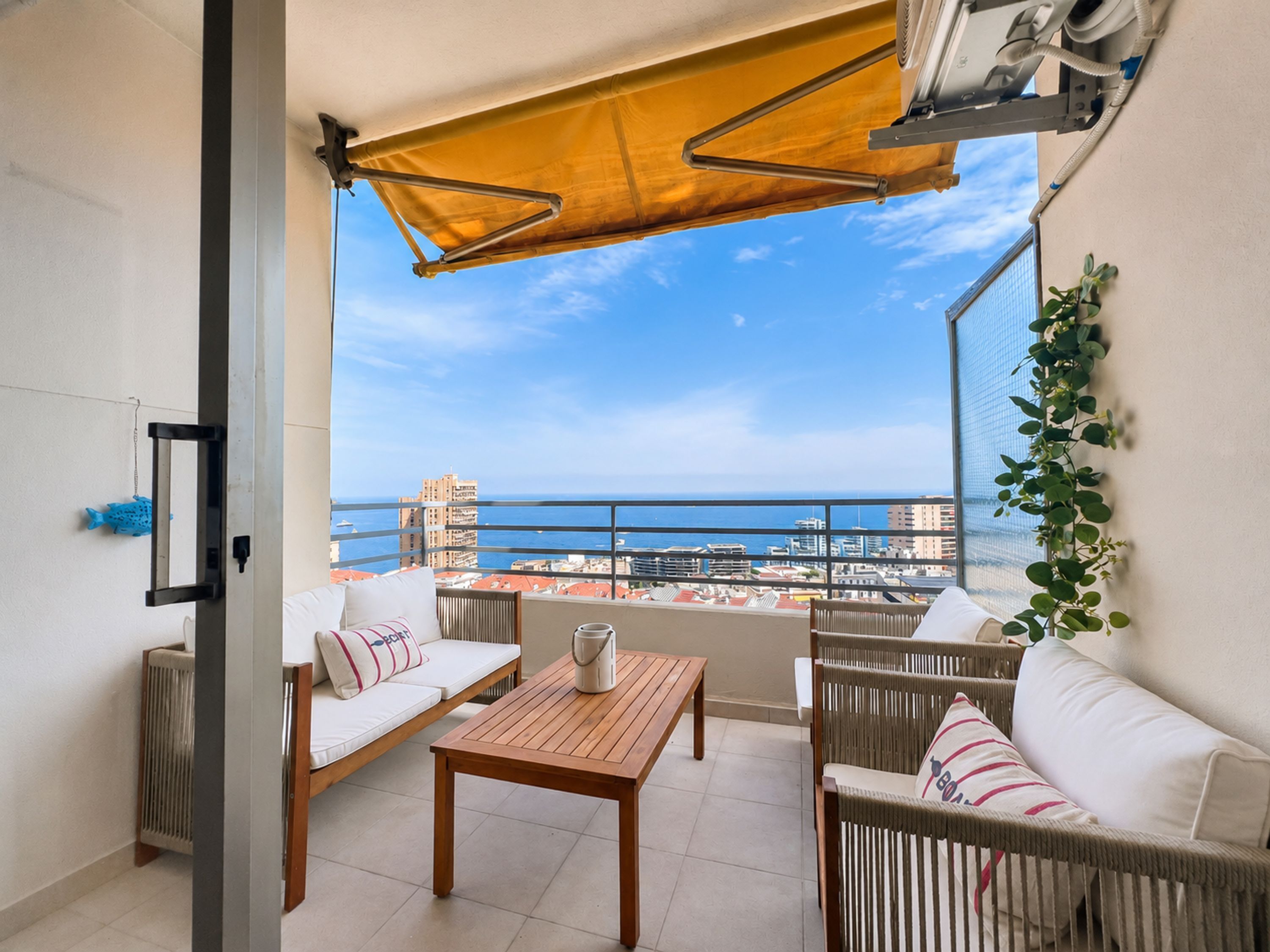 Un balcone con vista sul mare, arredato con un divano, sedie e un tavolo.