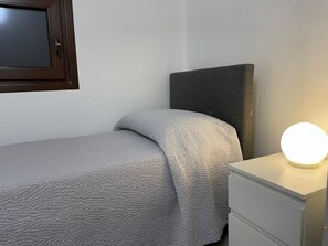 A bedroom with a bed, a bedside table with a lamp, and a window with a dark frame. - Arricriati near Ortigia by Wonderful Italy (Syracuse)