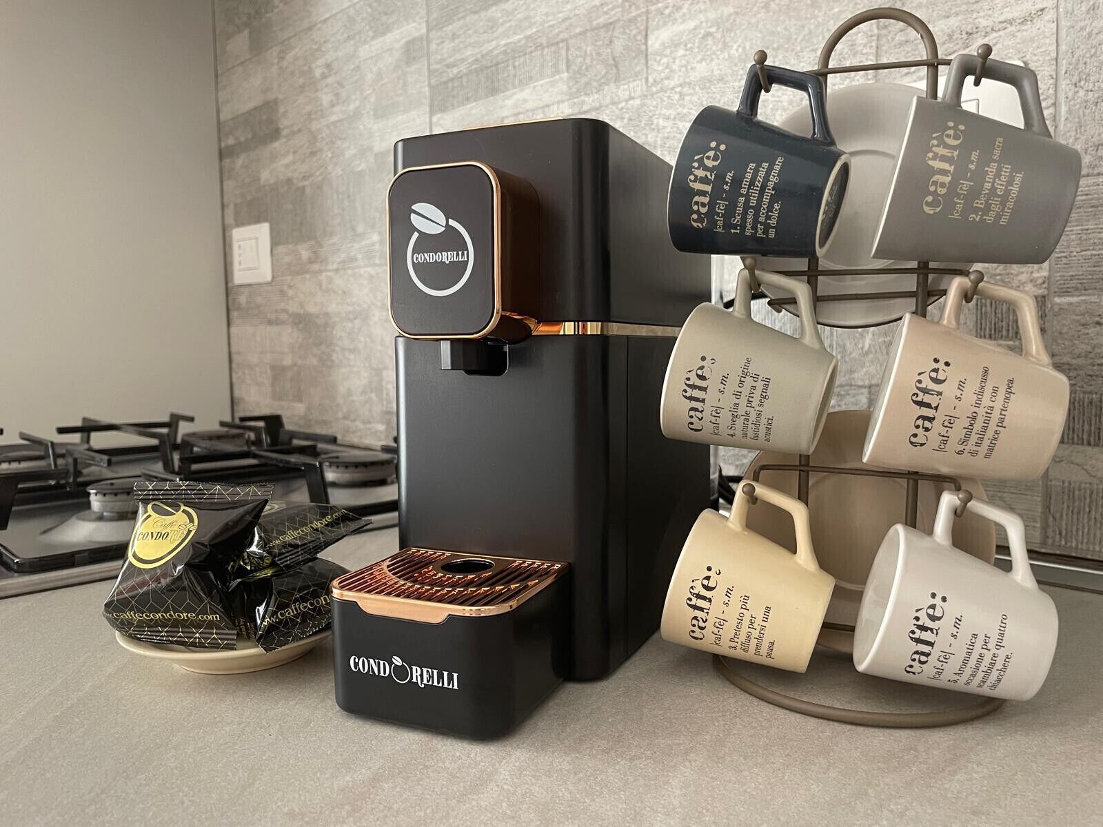 Una cafetera con un portavasos con el logo de la marca y un paquete de cápsulas de café.