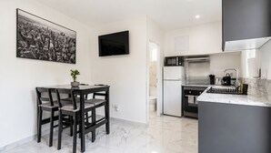 Una cucina moderna con zona pranzo, televisore a schermo piatto e pavimento in marmo.