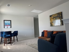 A living room with a blue sofa, a coffee table, and a framed picture on the wall. - New Community with pool Sleeps 14-16 Close to N MB (Conway)