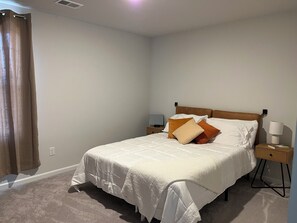 A bedroom with a bed, nightstands, a lamp, and a curtain. - New Community with pool Sleeps 14-16 Close to N MB (Conway)
