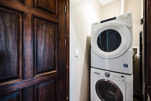 A laundry room with stacked washer and dryer units. - Stylish Oceanview Condo with Quick Beach Access, Modern Design & Spacious Balcony (Santa Cruz)