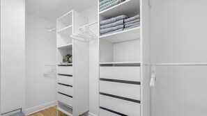 A white closet with multiple shelves and drawers, some containing folded towels. - Station Square Condominiums – Spacious Downtown Clearwater Retreat with Resort-Style Amenities (Clearwater)