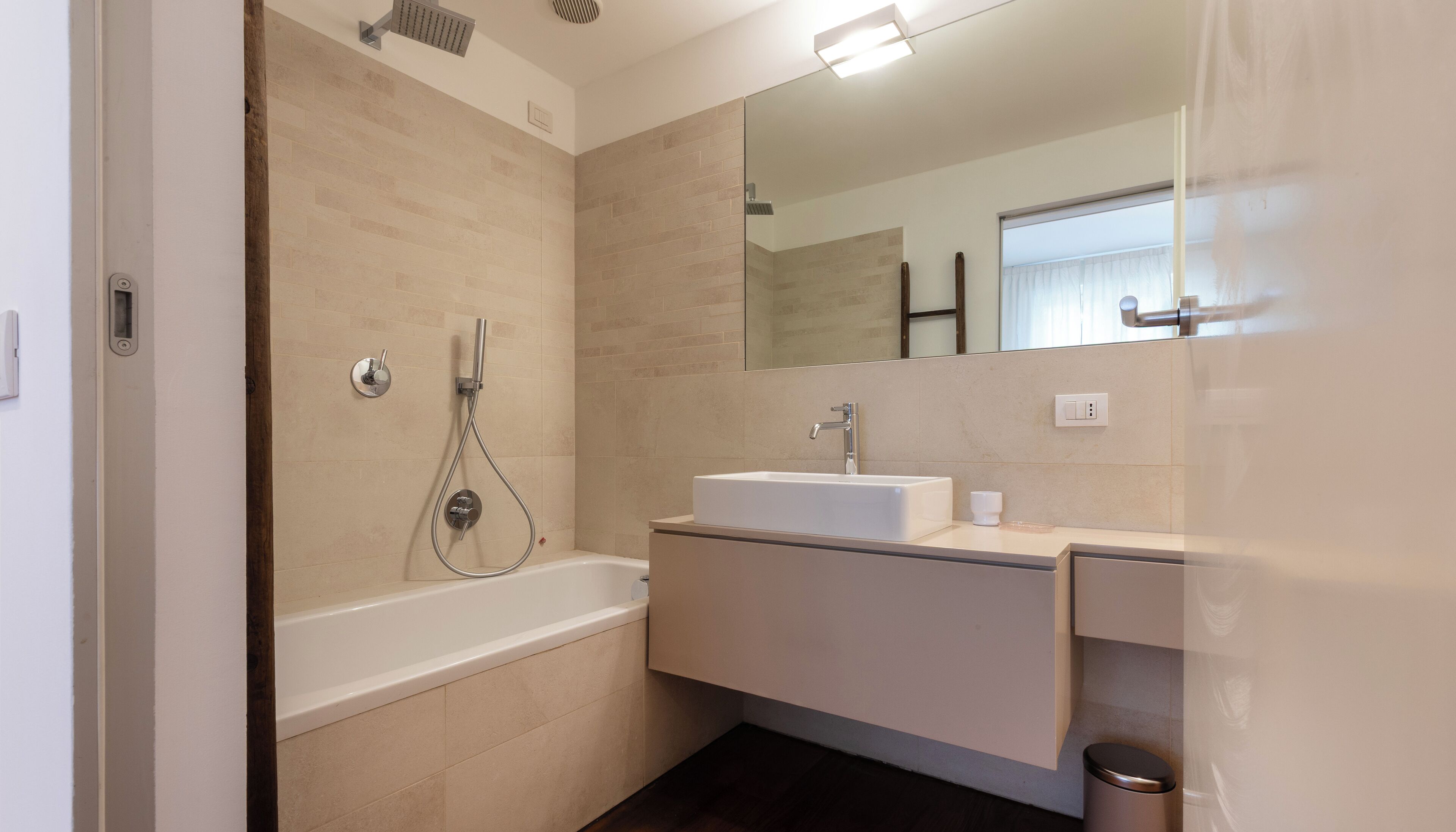 A modern bathroom with a bathtub, a sink, and a shower.