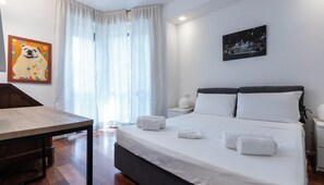 A hotel room with a bed, bedside tables, a desk, and a painting of a dog. - Italianway Comfort - Gherardini 2 (Milano)
