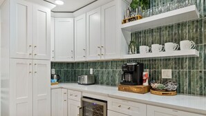 A kitchen with white cabinets, a coffee maker, a toaster, and a dish rack.