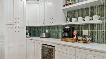 A kitchen with white cabinets, a coffee maker, a toaster, and a dish rack.
