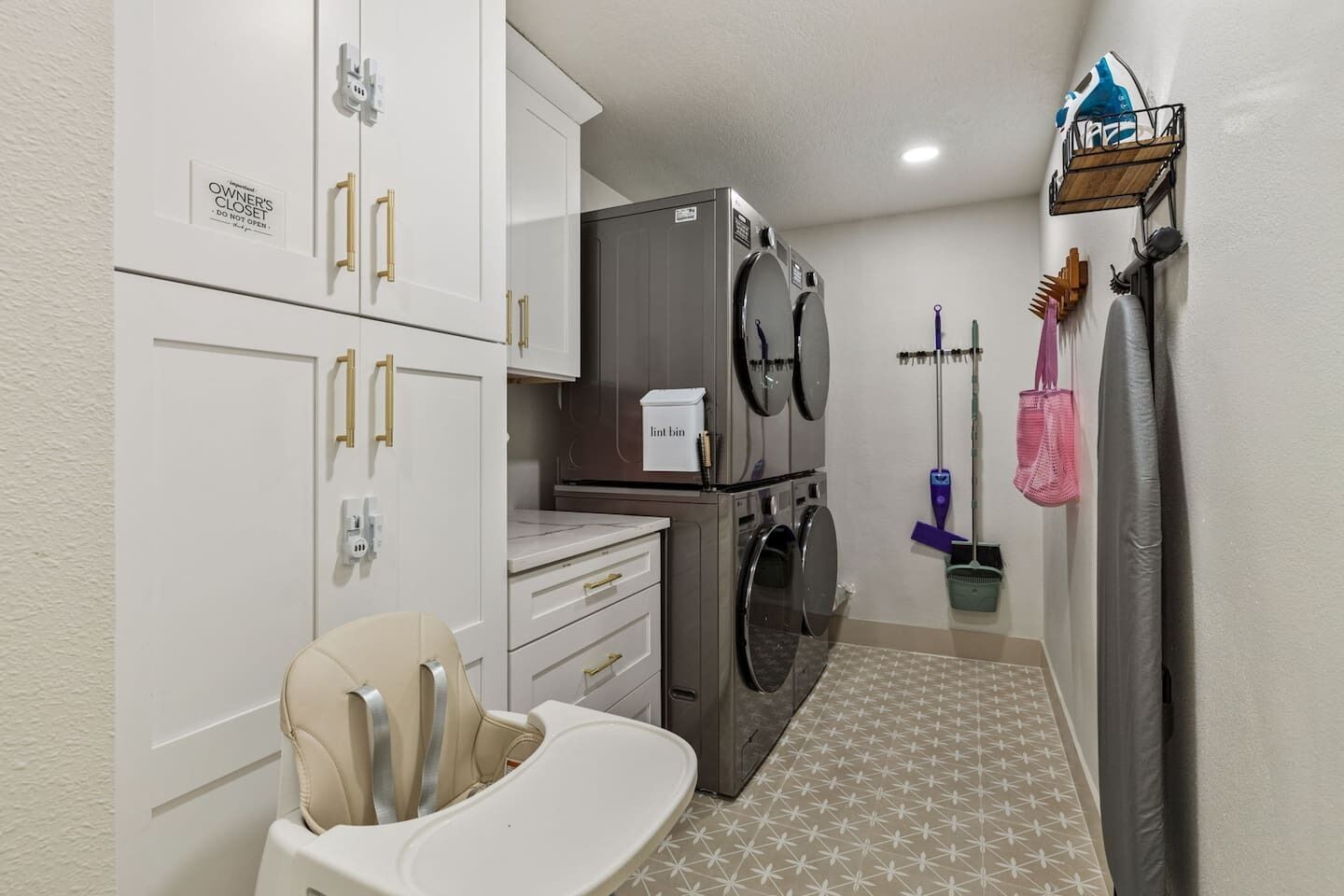 A laundry room with a washing machine, dryer, and a child's changing table.