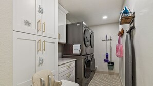 A laundry room with a washing machine, dryer, and a child's changing table.
