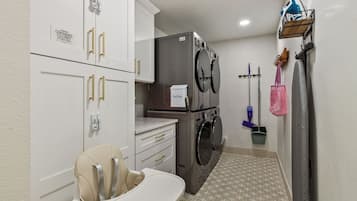 A laundry room with a washing machine, dryer, and a child's changing table.