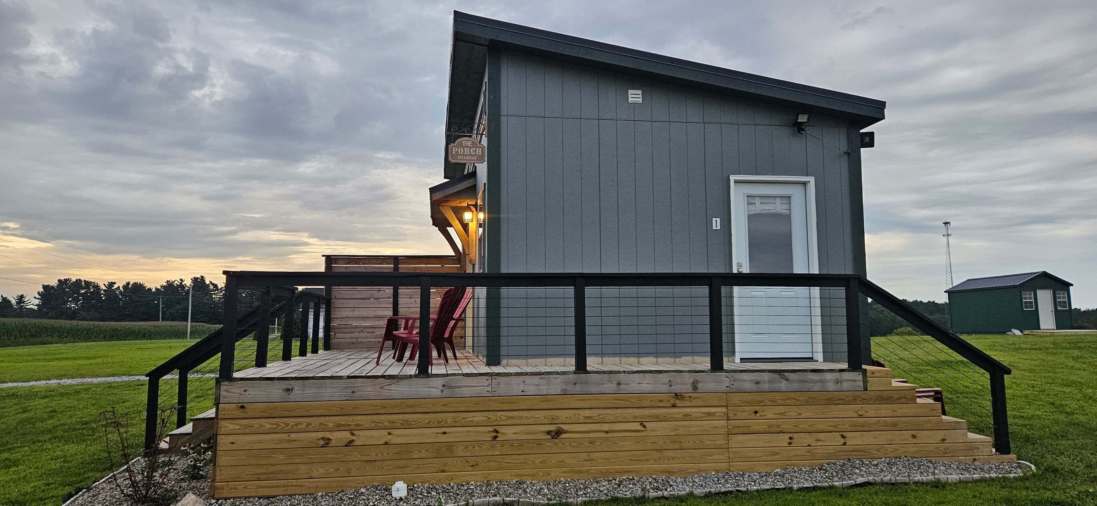 Un bâtiment moderne à deux étages, doté d’un balcon et d’une terrasse en bois.