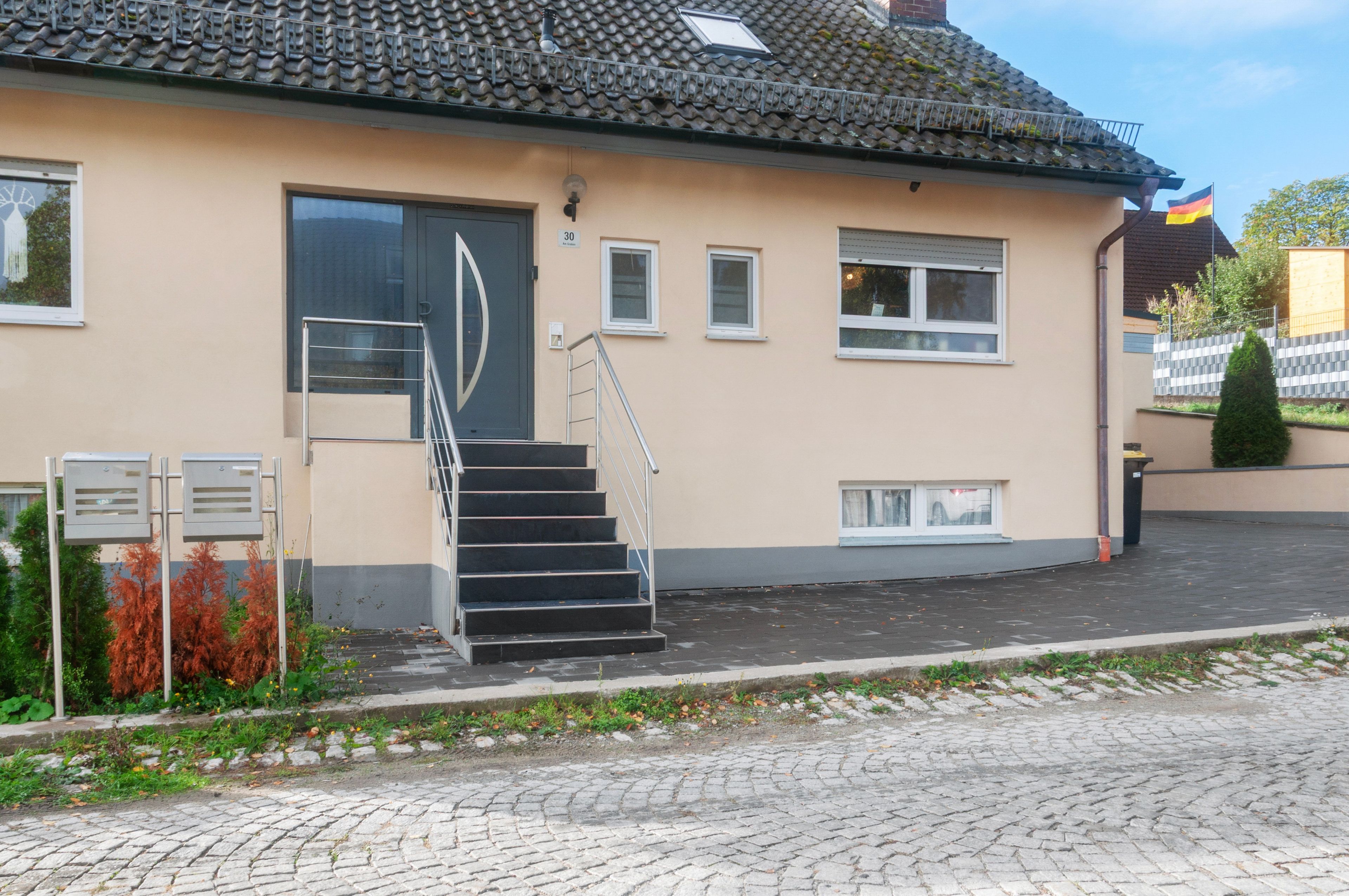 A building with a tiled roof, a staircase, and a door.