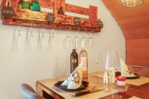 A wooden wine rack with bottles and glasses, a Buddha statue, and a table set with a bottle, glasses, and a decorative item. - Apartment 'Ferienwohnung Markt Bibart' (Markt Bibart)