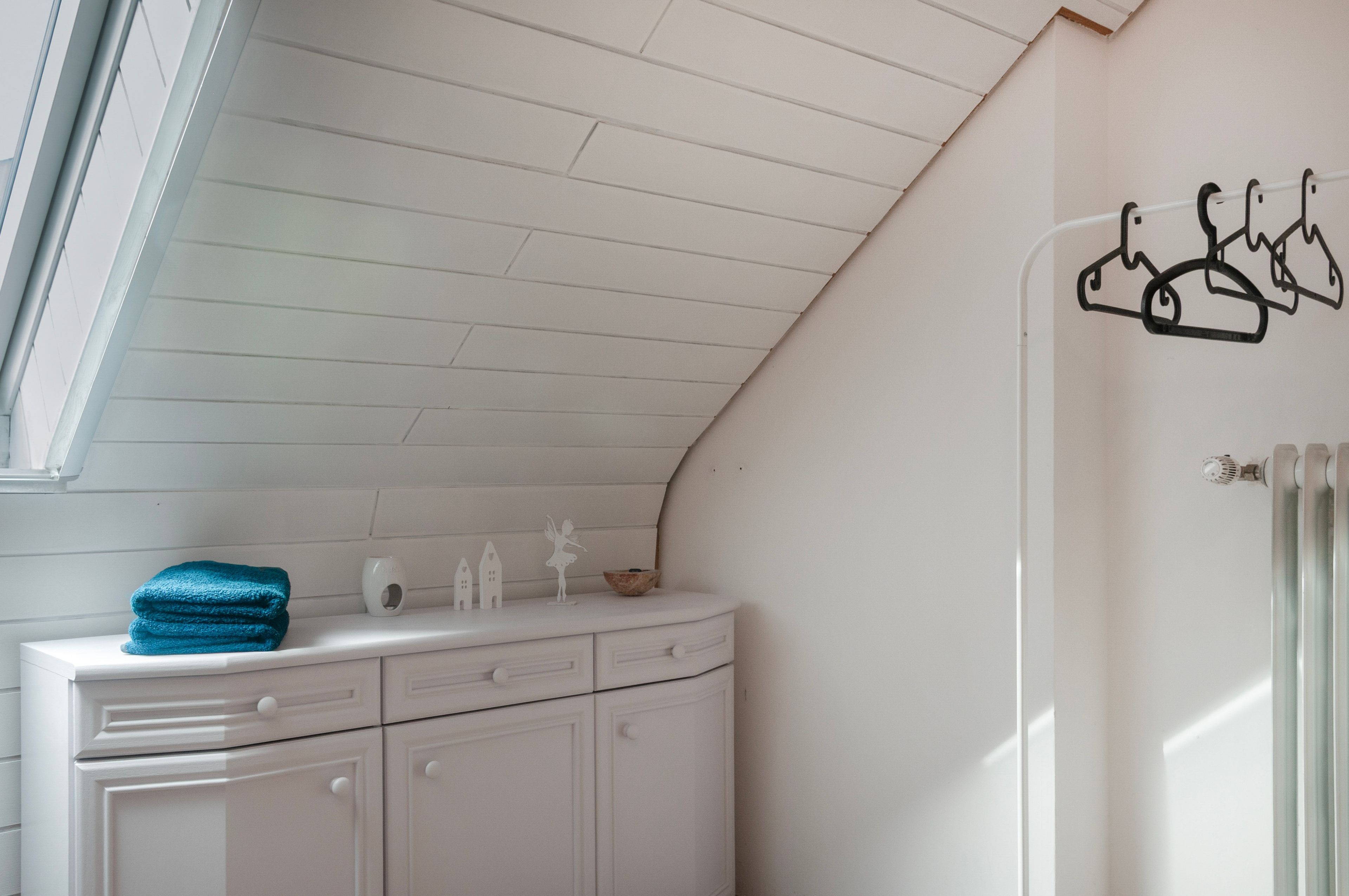Een badkamer met een wit wastafelmeubel, een handdoek en een handdoekradiator.