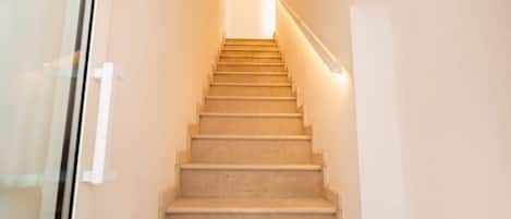 Una escalera con barandilla que lleva a una plataforma con una lámpara.